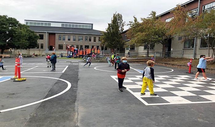 a playground with a building wrapping around two sides