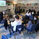 Students sitting at their desks researching on computers