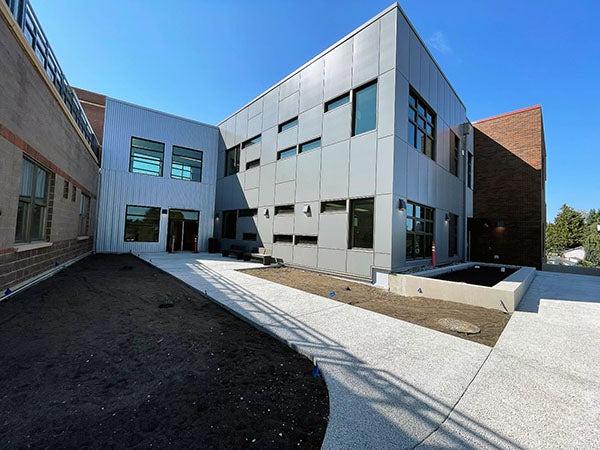 a metal clad wing of a brick building