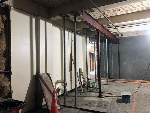 an indoor space under construction with steel posts and a steel beam