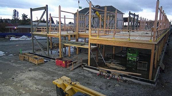 a structure is under construction with a historic building in the background