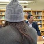 Superintendent Jones, Mayor Harrell, and Governor Inslee talk with students in the school library.