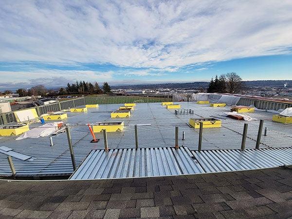 a meal roof has yellow boxes and a railing