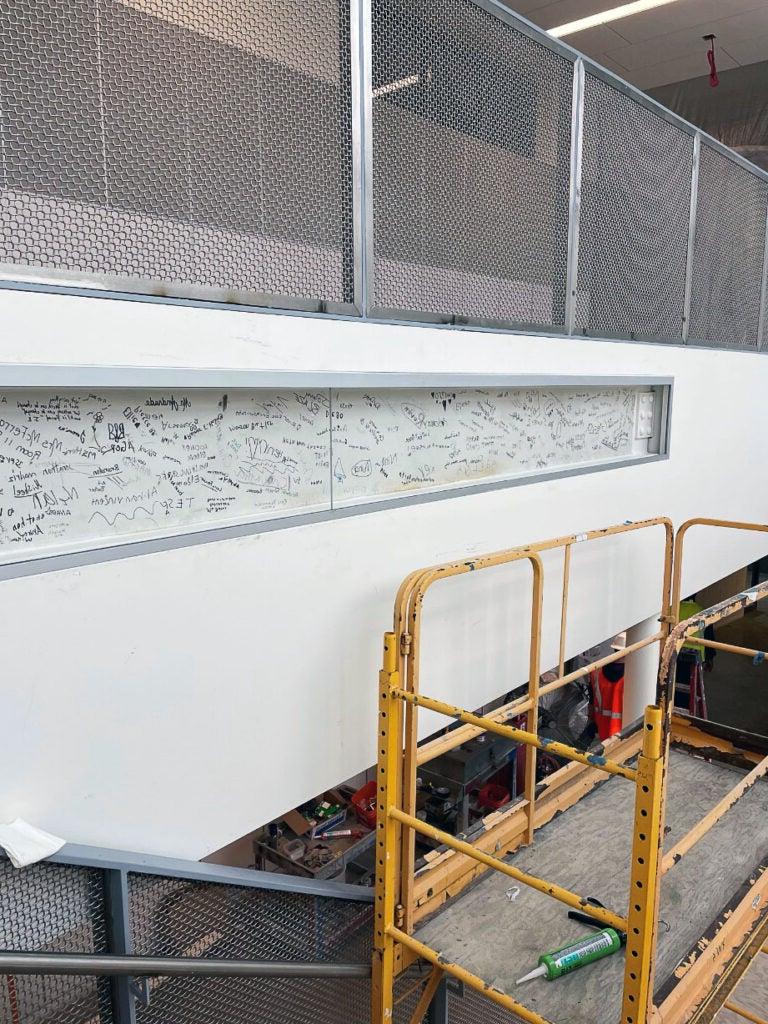 a wall on a stairwell has a signed steel beam embedded in it