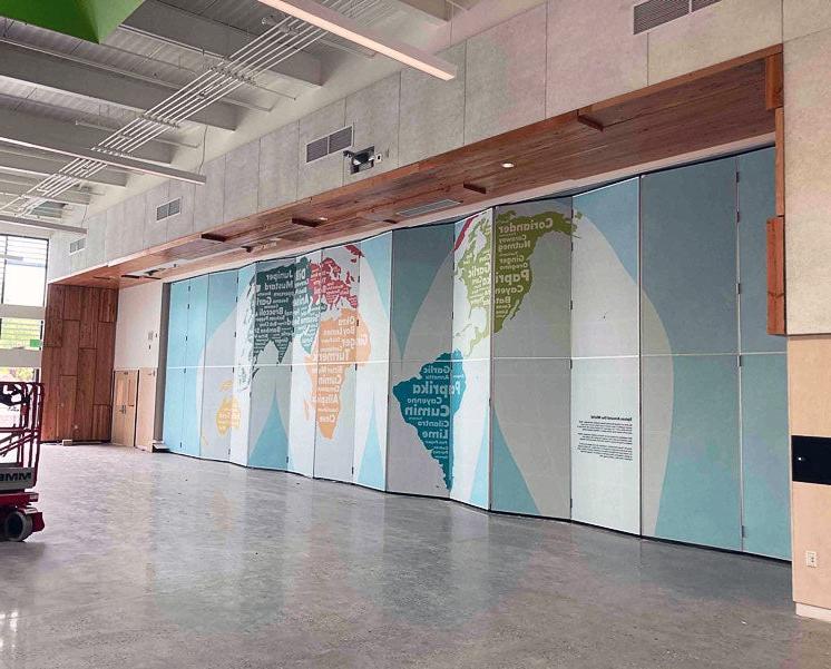 a wall has a indent that contains a very large section of folding wall covered with a map image