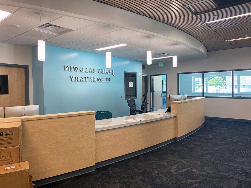 interior space with a reception desk. wall behind says James Baldwin Elementary