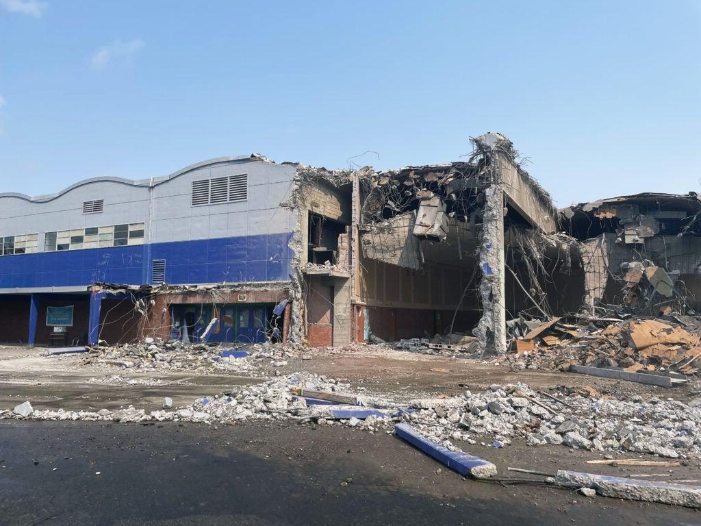 a partially demolished building. the remaining part of the building is two stories with a series of arched roofs