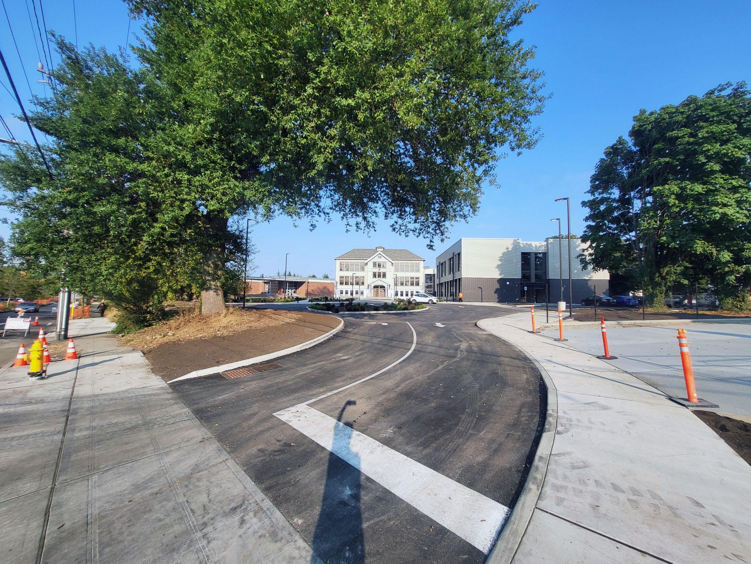 a three story historic building is directly ahead with a circle drive in front - a new 2 story building is to the left and a low brick building is to the right