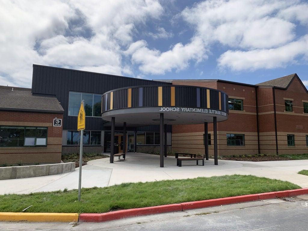 a circular canopy says West Seattle Elementary School and is in front of an entry door