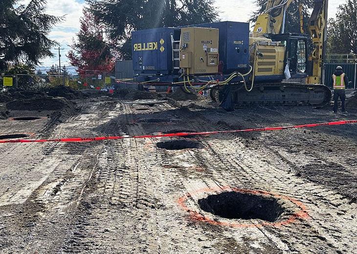 a large construction machine is on a field of soil that has large round holes in it