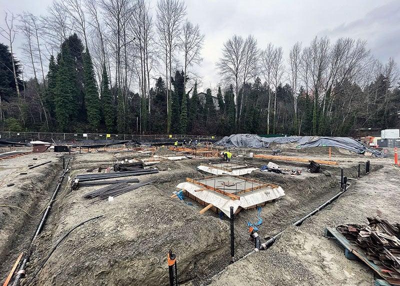 a dirt construction site with trenches and construction materials