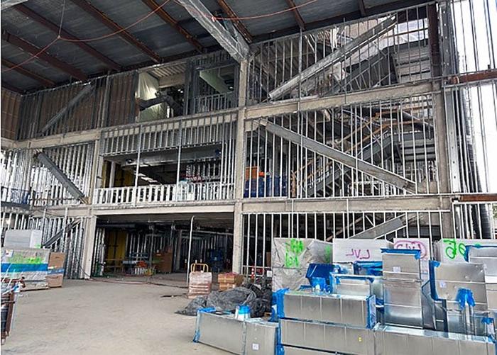 Interior of a building under construction with metal framing. metal ductwork pieces are stacked on the floor