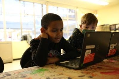 students working at laptops in a classroom