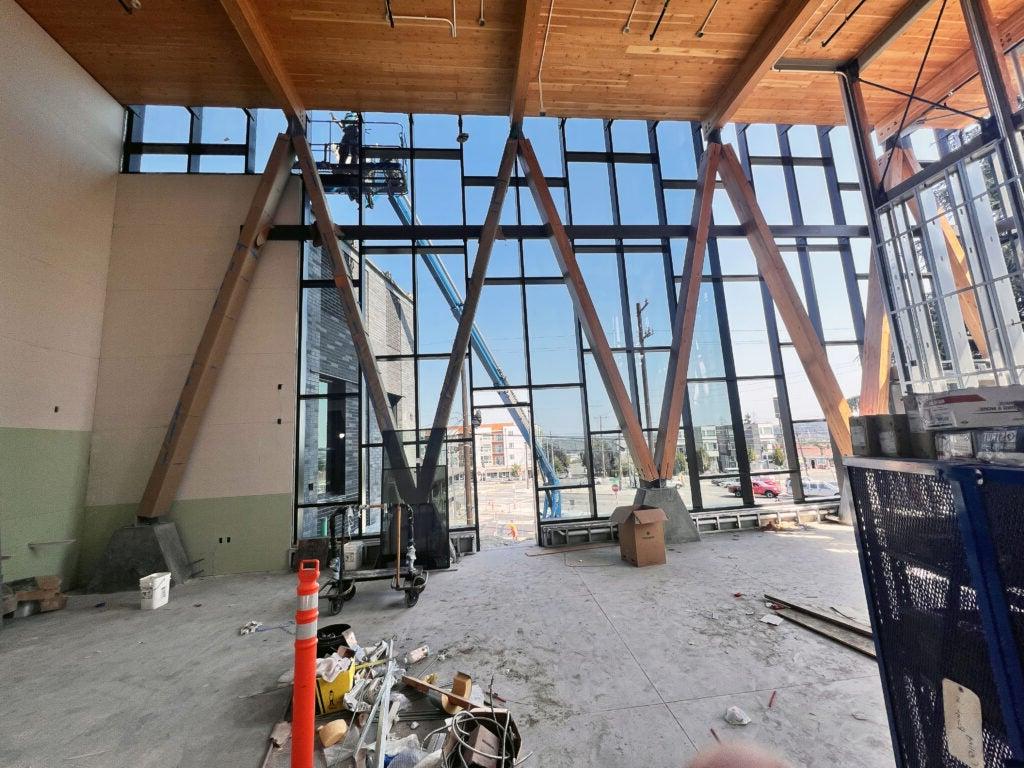 interior looking out through 2 story wall of windows with timber braces set in triangles