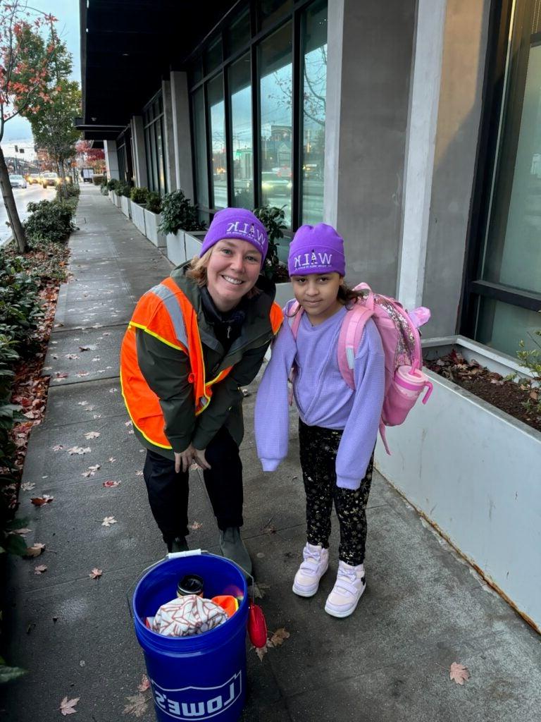 Student and adult with purple Ruby Bridges Day hats on their walk to school.