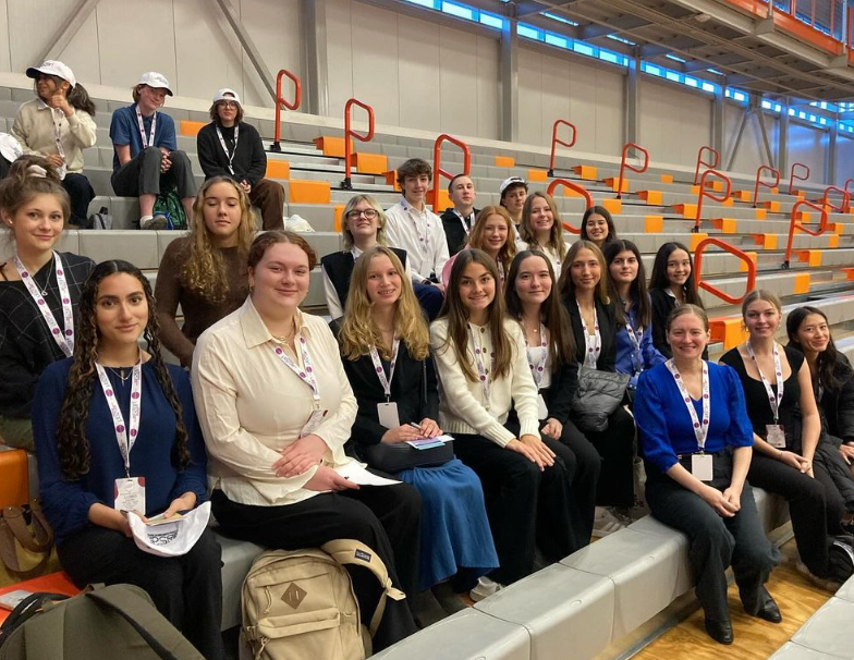 group of students sitting on bleachers at leadership conference