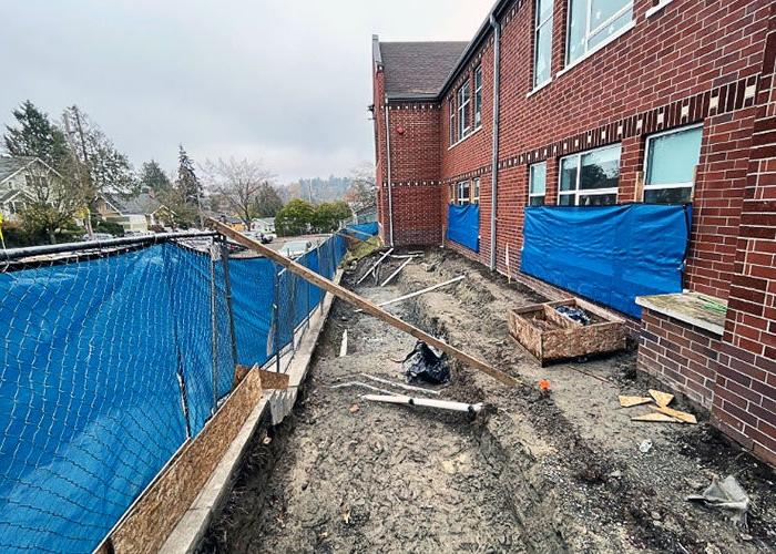 a long narrow hole next to a brick building