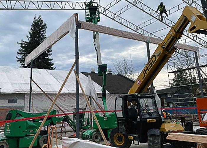 a building under construction with beams being lifted into place