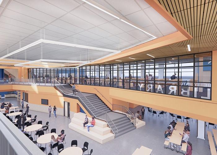 large common area with dining tables and stairs; a room with glass windows looking out toward below says LIBRARY