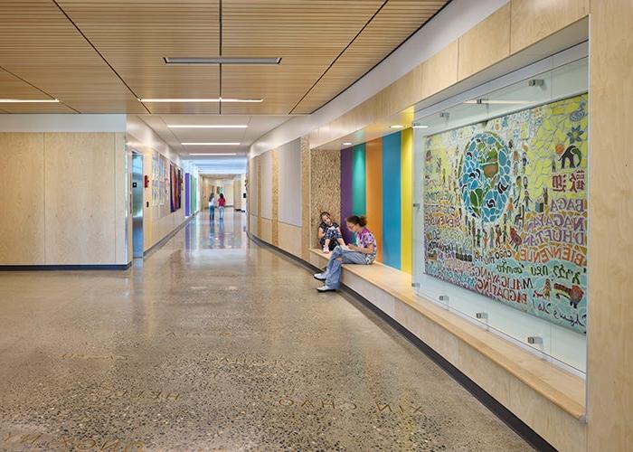 a hallway with a bench and a mural