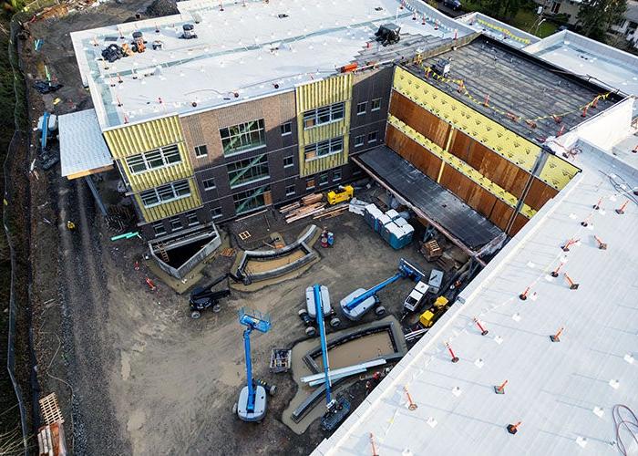 looking down between two wings of an unfinished building to where some planters are installed