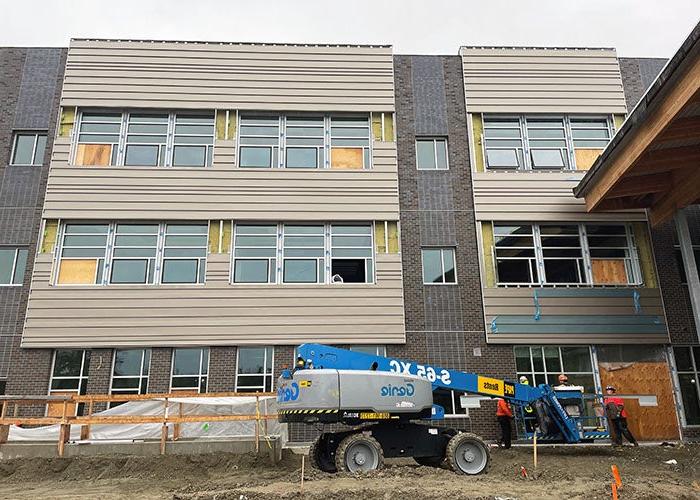 a part of a 3-story building with brown siding and windows